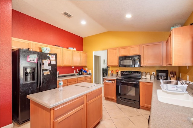 kitchen featuring light brown cabinetry, black appliances, a center island, and lofted ceiling