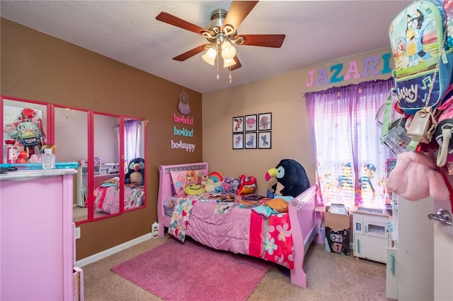 bedroom with a textured ceiling, light colored carpet, and ceiling fan