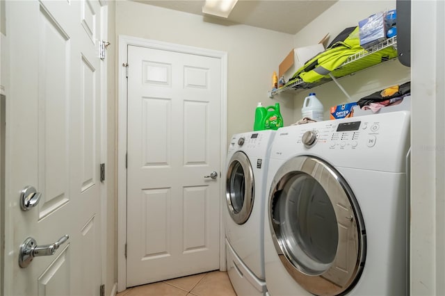 laundry room featuring washing machine and dryer and light tile patterned floors