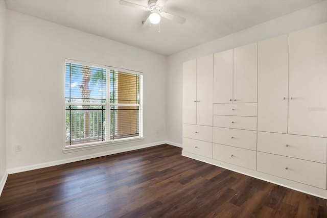 unfurnished bedroom with multiple windows, ceiling fan, and dark wood-type flooring