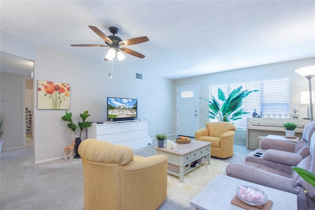 living room featuring a textured ceiling, light carpet, and ceiling fan