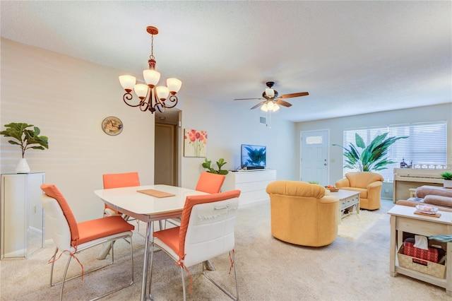 carpeted dining space featuring ceiling fan with notable chandelier