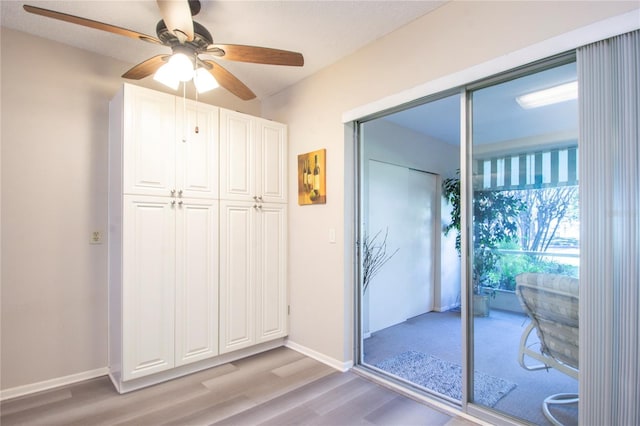 doorway to outside with ceiling fan and light wood-type flooring