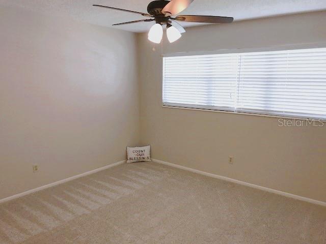 unfurnished room featuring light colored carpet and ceiling fan