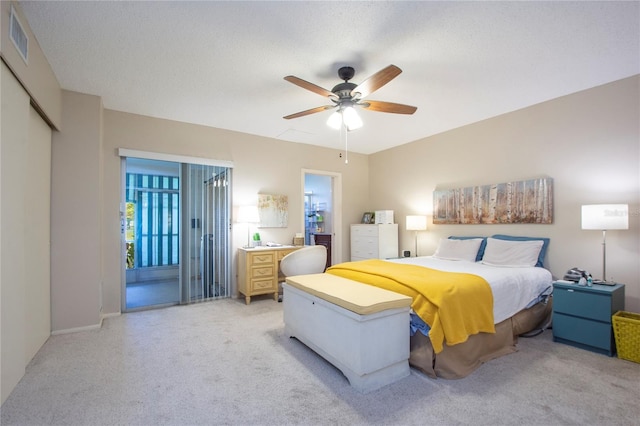 carpeted bedroom featuring a closet, access to outside, a textured ceiling, and ceiling fan