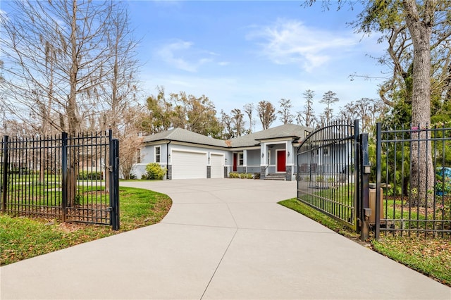 view of front of house featuring a garage, driveway, a gate, fence, and stucco siding