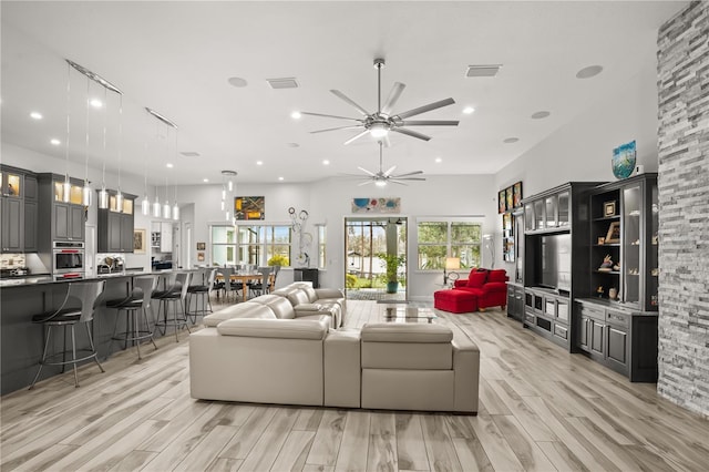 living room with ceiling fan, light wood-type flooring, visible vents, and recessed lighting