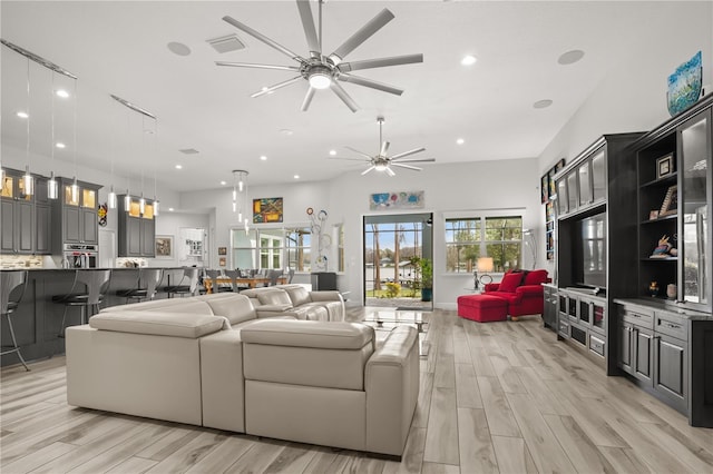 living area with light wood-style floors, visible vents, a ceiling fan, and recessed lighting