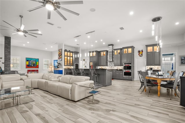 living area featuring light wood-style flooring, visible vents, a ceiling fan, and recessed lighting