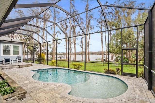 pool featuring a yard, glass enclosure, a patio, and a water view