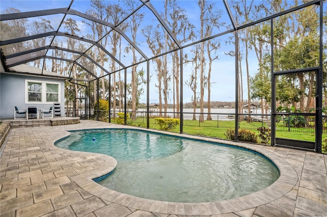 pool featuring a water view, a patio area, a lanai, and fence