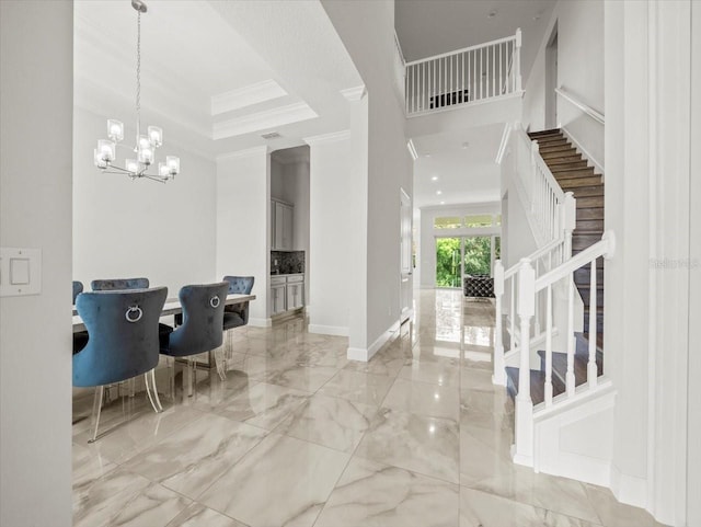 foyer featuring crown molding and a chandelier