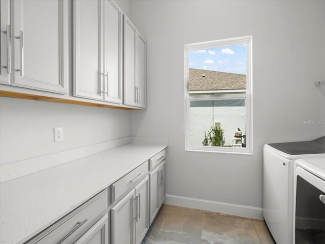 laundry room with washing machine and dryer and cabinets