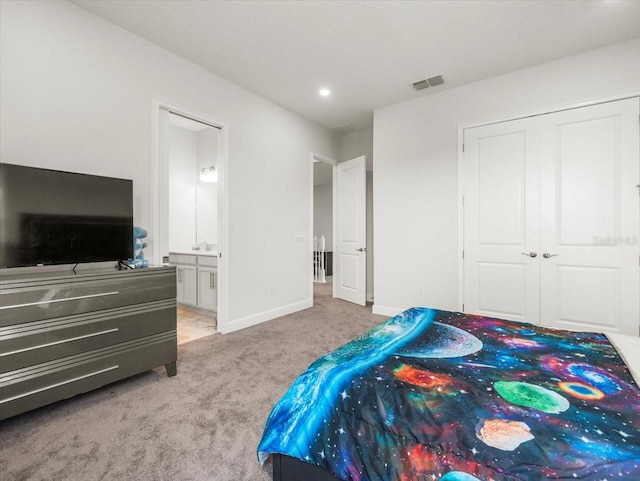 carpeted bedroom featuring ensuite bathroom and a closet