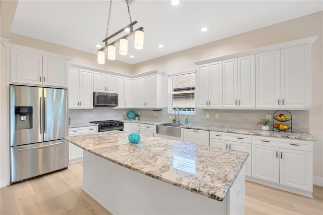 kitchen featuring white cabinetry, light wood-type flooring, and appliances with stainless steel finishes