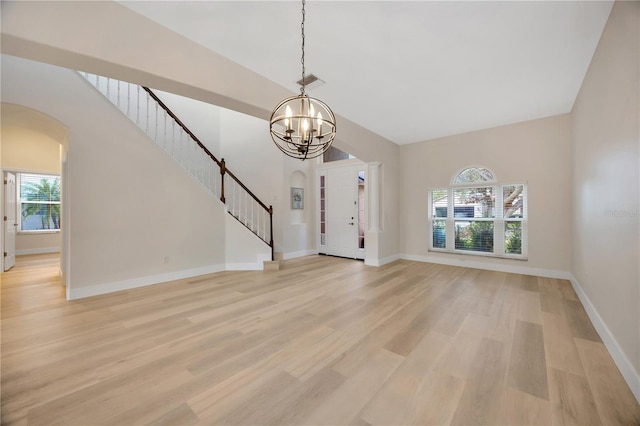 interior space with plenty of natural light, light wood-type flooring, and a notable chandelier