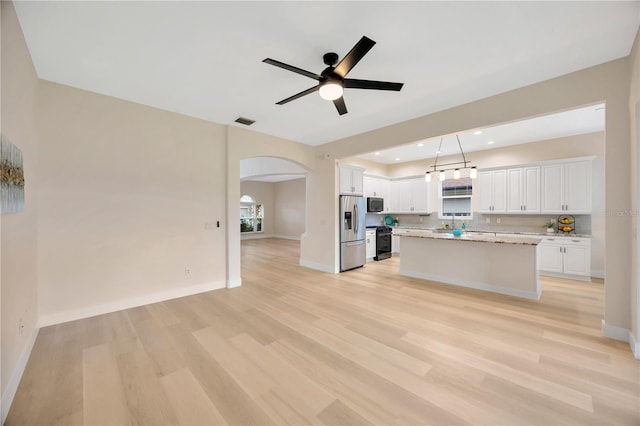 kitchen featuring white cabinetry, pendant lighting, appliances with stainless steel finishes, and a center island