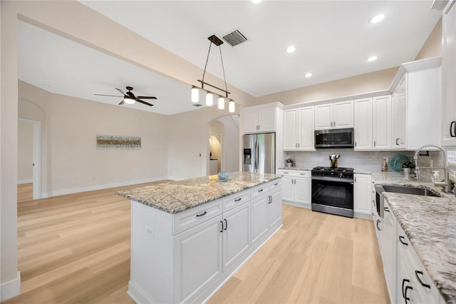 kitchen featuring white cabinetry, a kitchen island, and appliances with stainless steel finishes