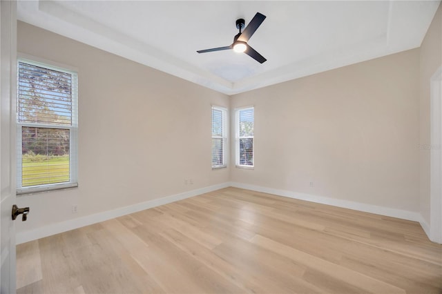 unfurnished room featuring a wealth of natural light, ceiling fan, and light hardwood / wood-style flooring