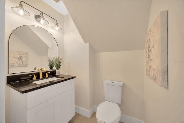 bathroom featuring toilet, vanity, and hardwood / wood-style floors