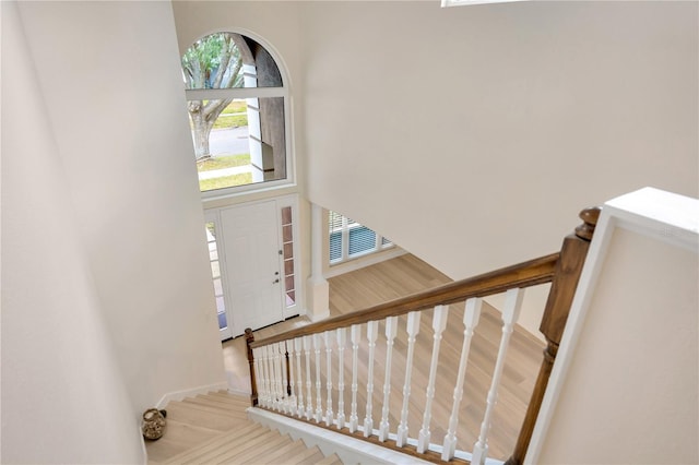 stairway featuring hardwood / wood-style flooring and a towering ceiling