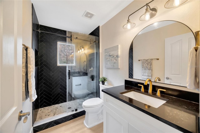 bathroom featuring toilet, vanity, hardwood / wood-style flooring, and walk in shower