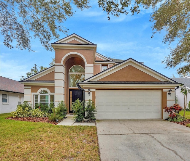 view of front of property featuring a front yard, an attached garage, driveway, and stucco siding