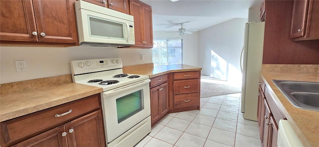 kitchen featuring ceiling fan, white appliances, sink, and light tile patterned flooring