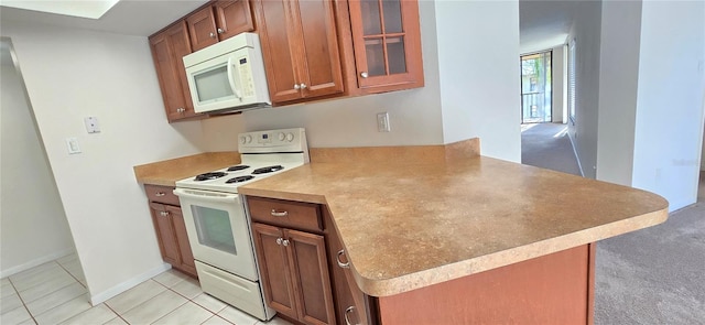 kitchen with kitchen peninsula, white appliances, and light tile patterned floors