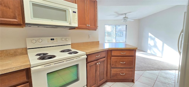 kitchen with kitchen peninsula, white appliances, ceiling fan, and light tile patterned flooring