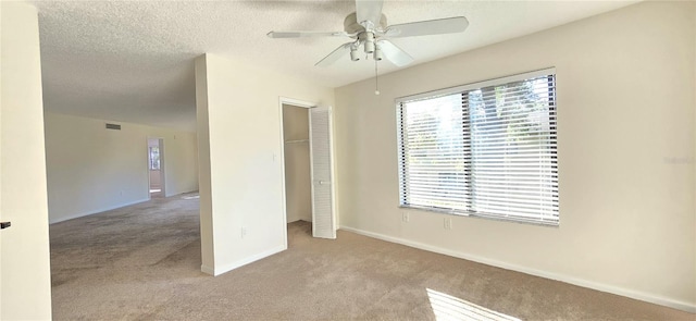 unfurnished bedroom featuring ceiling fan, light carpet, a closet, and a textured ceiling