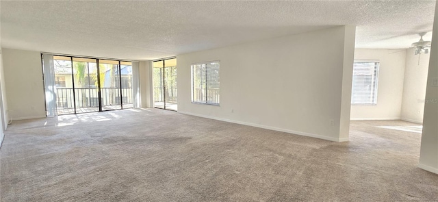 carpeted empty room with ceiling fan and a textured ceiling