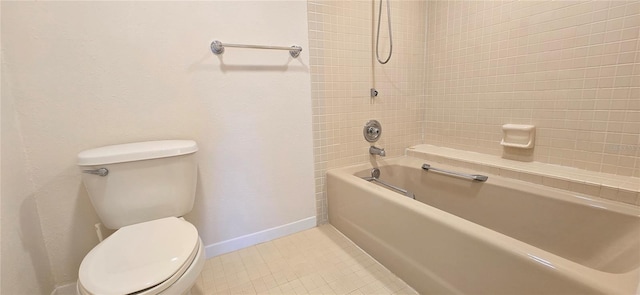 bathroom with toilet, tiled shower / bath, and tile patterned floors