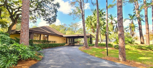 view of front of house with a carport and a front lawn