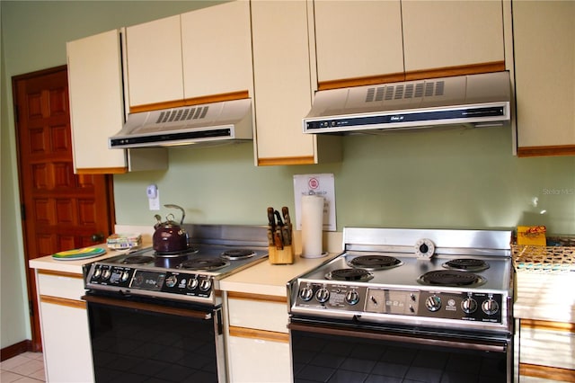 kitchen with light tile patterned floors, exhaust hood, black / electric stove, white cabinets, and gas range