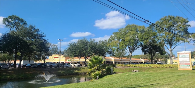 view of home's community featuring a lawn and a water view