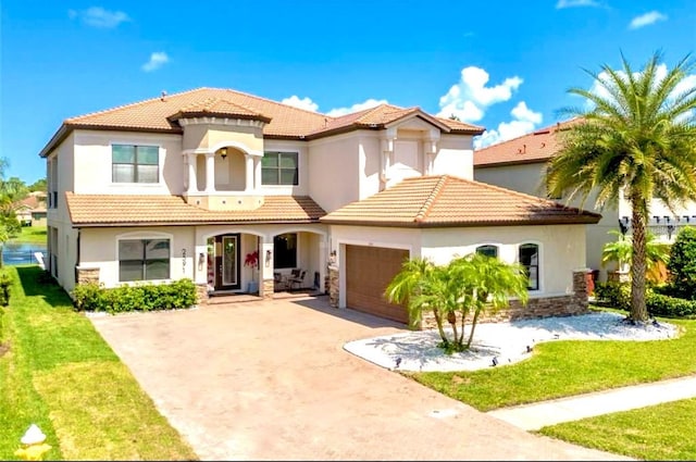 mediterranean / spanish-style home featuring a front yard and a garage