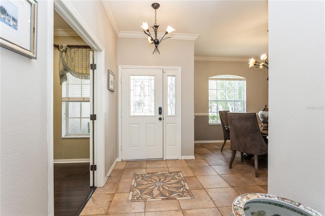 tiled foyer entrance featuring an inviting chandelier and ornamental molding