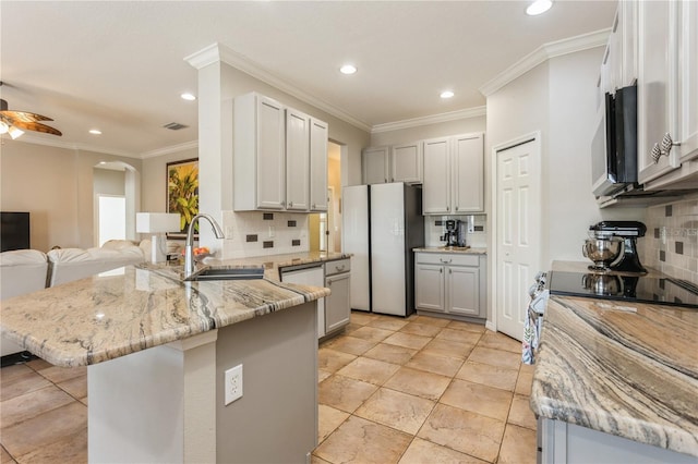 1433 Emerald Hill Way, Valrico, FL 33594 - kitchen featuring freestanding refrigerator, a peninsula, a sink, stainless steel microwave, and backsplash