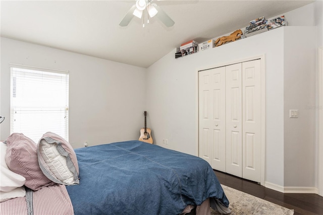 bedroom with lofted ceiling, a closet, dark wood-type flooring, and ceiling fan