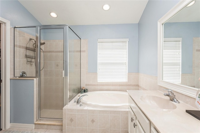 bathroom with vanity, tile patterned flooring, and plus walk in shower