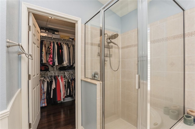 bathroom with a shower with shower door and hardwood / wood-style flooring