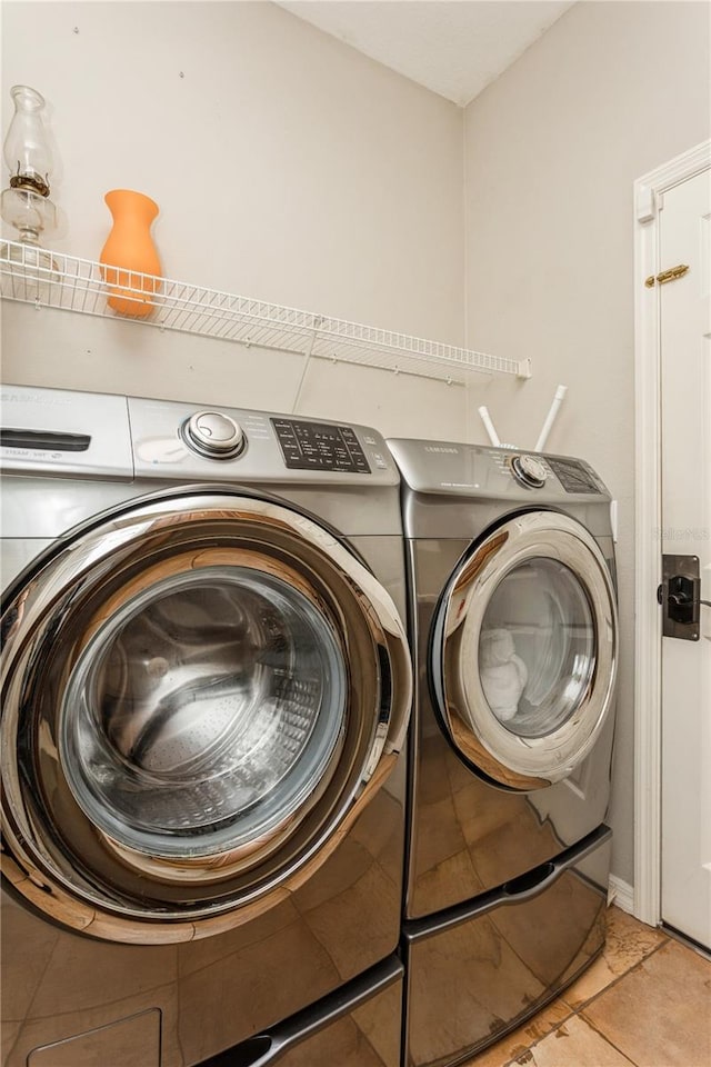 washroom with light tile patterned flooring and washer and dryer