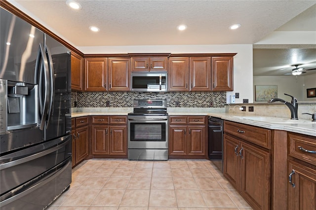 kitchen with appliances with stainless steel finishes, light tile patterned flooring, a sink, and backsplash