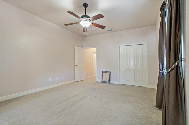 unfurnished bedroom with a closet, light colored carpet, visible vents, ceiling fan, and baseboards