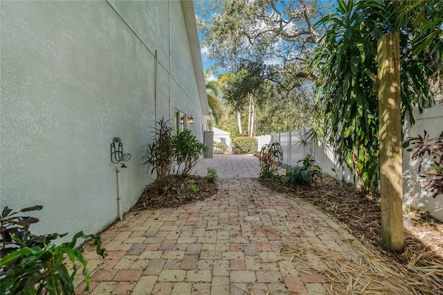 view of property exterior featuring a fenced backyard, a patio, and stucco siding