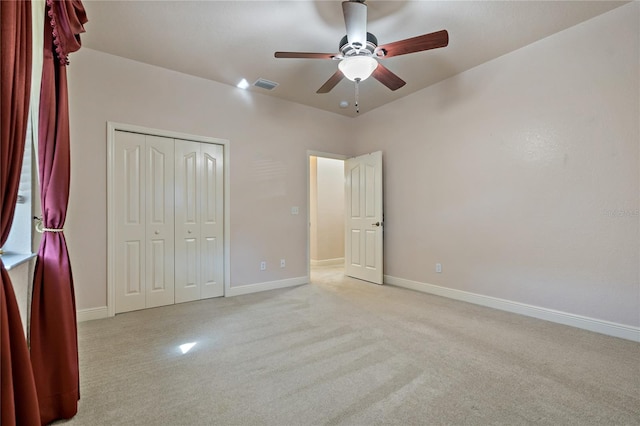 unfurnished bedroom with baseboards, visible vents, light colored carpet, ceiling fan, and a closet