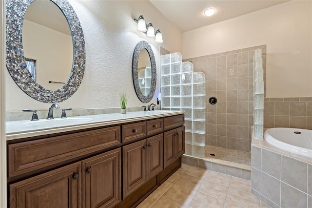 full bath with double vanity, walk in shower, tile patterned flooring, and a sink