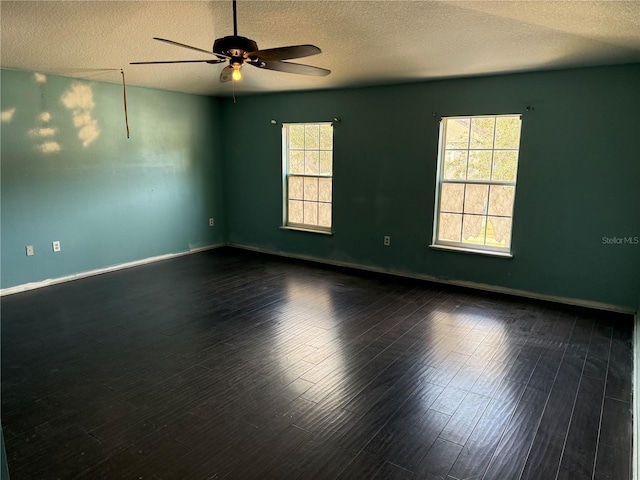 empty room featuring ceiling fan, a textured ceiling, and dark hardwood / wood-style floors