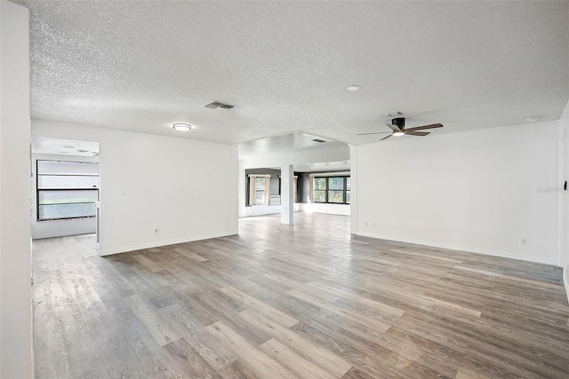 empty room with a textured ceiling, light hardwood / wood-style flooring, and ceiling fan